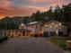 Stunning two-story home with a balcony, complemented by a gravel driveway and mountain views at sunset at 2571 Sw Grapevine Rd, Idledale, CO 80453