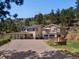 Stunning exterior view of two-story home, showcasing stone accents, garage, deck and beautiful landscaping at 2571 Sw Grapevine Rd, Idledale, CO 80453