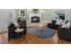 Cozy living room featuring a stone fireplace, dark armchairs, and an area rug on hardwood floors at 2571 Sw Grapevine Rd, Idledale, CO 80453