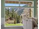 Bright living room view with large windows offering panoramic views of the lush mountain landscape at 2571 Sw Grapevine Rd, Idledale, CO 80453