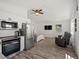 Open concept living space features a mini-kitchen with stainless steel appliances, TV, and two recliners at 2571 Sw Grapevine Rd, Idledale, CO 80453