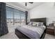 Bedroom showcases a large window with blinds, ceiling fan, and decorative pillows on the bed at 5251 Central Park Blvd, Denver, CO 80238