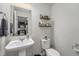 Half bathroom features a pedestal sink, toilet, and decorative shelves at 5251 Central Park Blvd, Denver, CO 80238