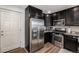 Modern kitchen features black cabinets, stainless steel appliances, and wood-look flooring at 5251 Central Park Blvd, Denver, CO 80238