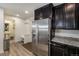 Efficient kitchen featuring stainless steel appliances, dark cabinets, and easy access to the mud room at 5251 Central Park Blvd, Denver, CO 80238