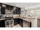 Modern kitchen showcasing stainless steel appliances, dark cabinetry, and convenient breakfast bar at 5251 Central Park Blvd, Denver, CO 80238