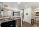 Open kitchen view shows a stainless steel dishwasher, sink, staircase, and entry to a half bathroom at 5251 Central Park Blvd, Denver, CO 80238