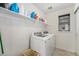 Laundry room showcases a washer, dryer, a shelf for supplies, and a window at 5251 Central Park Blvd, Denver, CO 80238