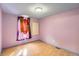 Bright bedroom featuring wood floors, a window with curtains, and pink walls at 441 Johnson St, Frederick, CO 80530