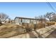 Exterior view of a charming light blue home with a picket fence and quaint landscaping at 441 Johnson St, Frederick, CO 80530
