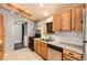 Kitchen featuring stainless steel appliances, wooden cabinets, and bright tile floor at 441 Johnson St, Frederick, CO 80530