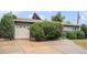 A driveway leading to an attached garage with mature landscaping in the front yard at 9590 Lowell Blvd, Westminster, CO 80031