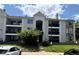 Multi-level condo building with balconies, stone accents, tidy landscaping, and street parking at 12304 W Cross Dr # 304, Littleton, CO 80127