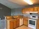 Bright kitchen with granite countertops, oak cabinets, stainless steel sink and white appliances at 12304 W Cross Dr # 304, Littleton, CO 80127