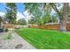 The property offers a spacious yard, with a wooden fence, green grass, stone landscaping, and an outdoor dining area at 6147 Jellison Way, Arvada, CO 80004