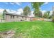 The property features a spacious backyard with lush lawn, patio with outdoor furniture, and a secure wood fence at 6147 Jellison Way, Arvada, CO 80004