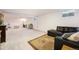 Finished basement with a carpeted floor, black leather sofa, and plenty of space at 6147 Jellison Way, Arvada, CO 80004