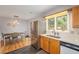 Bright kitchen with stainless steel refrigerator, window over sink, and adjacent dining area at 6147 Jellison Way, Arvada, CO 80004