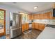 Bright kitchen with stainless steel refrigerator, wood cabinets, and a view of backyard at 6147 Jellison Way, Arvada, CO 80004