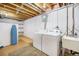 Basement laundry room with white washer and dryer, utility sink, and an ironing board offering practical convenience at 6147 Jellison Way, Arvada, CO 80004