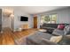 Open living room featuring hardwood floors, a gray sofa, and a large window at 6147 Jellison Way, Arvada, CO 80004