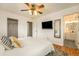 Bright main bedroom featuring a ceiling fan, walk-in closet, television, and a full bathroom at 6147 Jellison Way, Arvada, CO 80004
