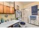 Bathroom featuring a shower-tub combo with glass door, vanity sink, and wooden medicine cabinet at 125 S Fulton Ave, Fort Lupton, CO 80621