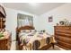 Traditional bedroom with wooden furniture, neutral carpet, and a circle patterned comforter at 125 S Fulton Ave, Fort Lupton, CO 80621