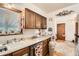 Traditional kitchen featuring wood cabinets and laminate countertops near a sunny window at 125 S Fulton Ave, Fort Lupton, CO 80621