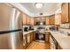 Bright kitchen with stainless steel appliances, light wood cabinets, and laminate countertops at 125 S Fulton Ave, Fort Lupton, CO 80621