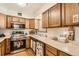 Functional kitchen with stainless steel appliances, light wood cabinets, and durable laminate countertops at 125 S Fulton Ave, Fort Lupton, CO 80621