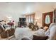 A cozy carpeted living room with ample seating, a fireplace, and natural light streaming through the windows at 125 S Fulton Ave, Fort Lupton, CO 80621