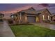Charming single-Gathering home showcasing a stone exterior, attached garage, and well-maintained lawn at dusk at 24943 E Phillips Pl, Aurora, CO 80016