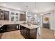 Open-concept kitchen with a large island, dark cabinets, and hardwood floors flowing into living spaces at 24943 E Phillips Pl, Aurora, CO 80016
