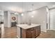 View of a kitchen island with seating, dark wood cabinets, and hardwood floors with access to dining area at 24943 E Phillips Pl, Aurora, CO 80016