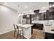 Well-appointed kitchen showcases stainless steel appliances, a center island, and dark cabinets with hardwood floors at 24943 E Phillips Pl, Aurora, CO 80016