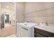 Convenient laundry area with sink, washer/dryer, and overhead shelf at 24943 E Phillips Pl, Aurora, CO 80016