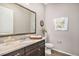 Elegant powder room with dark vanity, light countertop, and decorative mirror at 24943 E Phillips Pl, Aurora, CO 80016