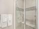 Clean shower with glass doors, grab bar, seat, and decorative tiling at 24943 E Phillips Pl, Aurora, CO 80016