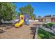 Community playground with play structure and mulch in fenced in yard at 8075 Wolff St # H, Westminster, CO 80031