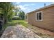 Spacious backyard with a concrete patio, lush lawn, mature trees, and well-maintained siding and windows at 1865 S Knox Ct, Denver, CO 80219
