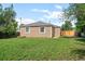 Home featuring a large, grassy backyard and wood fencing at 1865 S Knox Ct, Denver, CO 80219