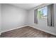Cozy bedroom featuring a large window that provides plenty of natural light, and stylish hardwood floors at 1865 S Knox Ct, Denver, CO 80219