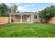 Charming single-story home featuring a covered porch, well-maintained lawn, complemented by a stylish wooden fence at 1865 S Knox Ct, Denver, CO 80219