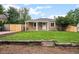 Charming single-story home featuring a covered porch, well-maintained lawn, and a rustic wooden retaining wall at 1865 S Knox Ct, Denver, CO 80219