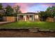 Charming single-story home featuring a covered porch, well-maintained lawn, and a rustic wooden retaining wall at 1865 S Knox Ct, Denver, CO 80219
