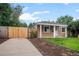 This charming home boasts a spacious driveway and a well-manicured lawn, enhanced by a stylish, light-colored fence at 1865 S Knox Ct, Denver, CO 80219