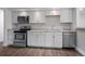 Updated kitchen featuring white cabinets, stainless steel appliances, and granite countertops at 1865 S Knox Ct, Denver, CO 80219