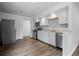 Modern kitchen featuring white cabinets, stainless steel appliances, granite countertops, and hardwood floors at 1865 S Knox Ct, Denver, CO 80219