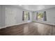Bright living room featuring hardwood floors, neutral walls, and multiple windows providing ample natural light at 1865 S Knox Ct, Denver, CO 80219